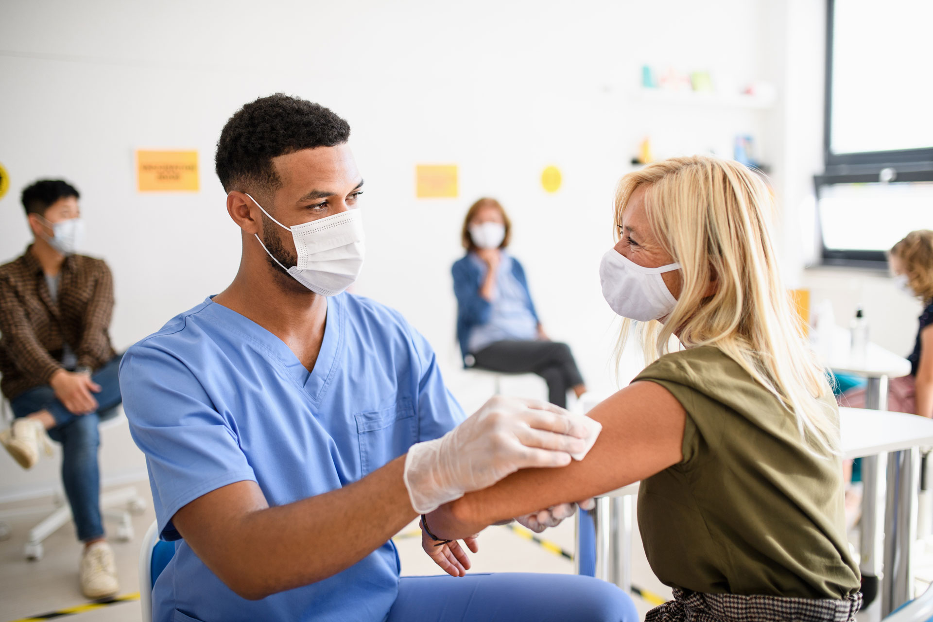 frontline workers administering an injection to a healthcare patient